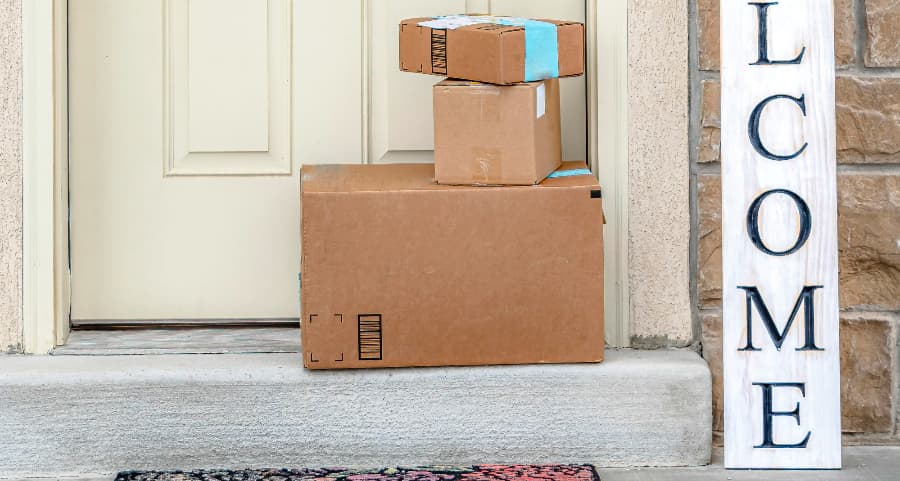 Packages on the doorstep of a home with a welcome sign in Olympia